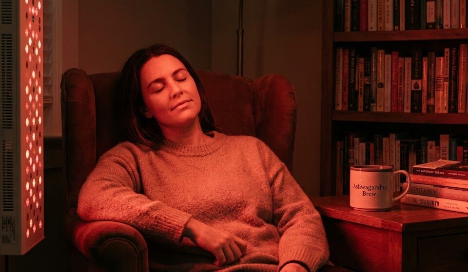 Bliższe ujęcie osoby odpoczywającej wieczorem w świetle lampy emitującej czerwone światło (RLT).