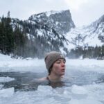 Profesjonalne zdjęcie przedstawiające osobę w trakcie sesji krioterapii w naturalnych warunkach.