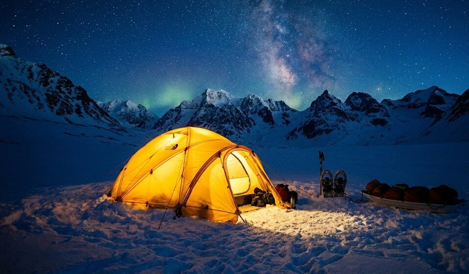 Zdjęcie namiotu ekspedycyjnego rozbitego na śniegu w samym sercu gór.