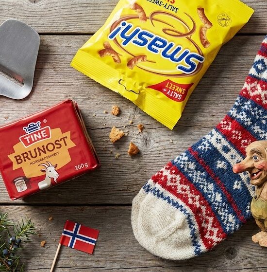 Zdjęcie w stylu flat lay przedstawiające zestaw klasycznych norweskich pamiątek na drewnianym stole