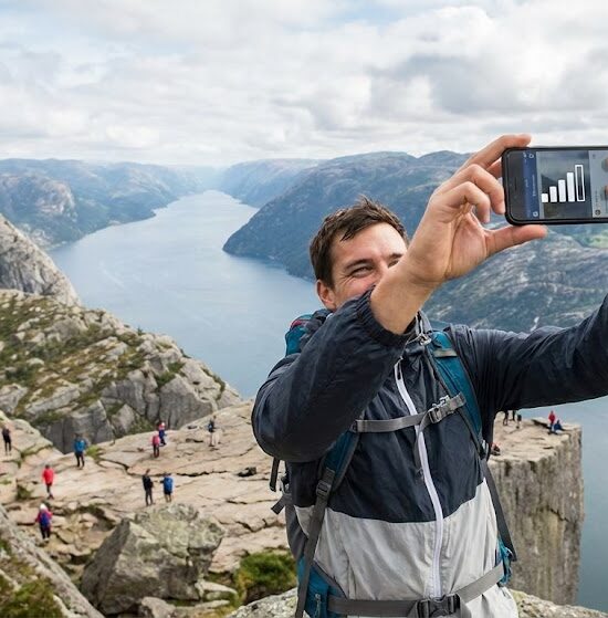 zdjęcie turysty robiącego selfie na szczycie Preikestolen.