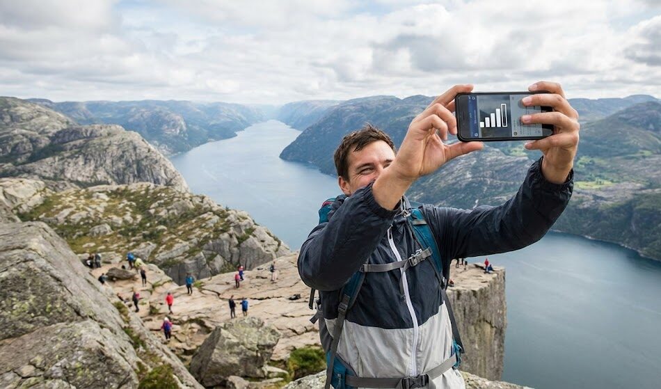 zdjęcie turysty robiącego selfie na szczycie Preikestolen.