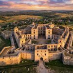 Epickie, szerokie ujęcie Zamku Krzyżtopór z lotu ptaka (z drona) w świetle zachodzącego słońca.