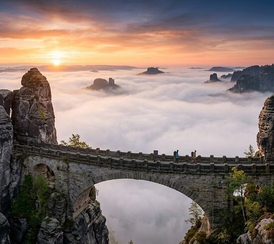 Epickie ujęcie słynnego kamiennego mostu Bastei (Basteibrücke) w Saksońskiej Szwajcarii o wschodzie słońca