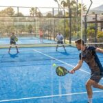 Panoramiczne zdjęcie pokazujące otwarty kort do padla w słoneczny dzień.