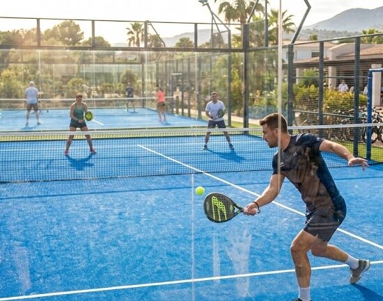 Panoramiczne zdjęcie pokazujące otwarty kort do padla w słoneczny dzień.