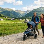 Szeroki kadr z Doliny Chochołowskiej. Na pierwszym planie młodzi rodzice pchają sportowy wózek