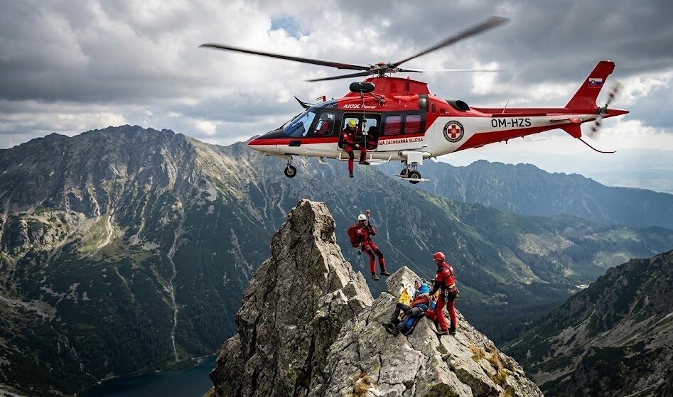 Dramatyczny kadr przedstawiający czerwono biały helikopter słowackiej Horskiej Záchrannej Služby (HZS)