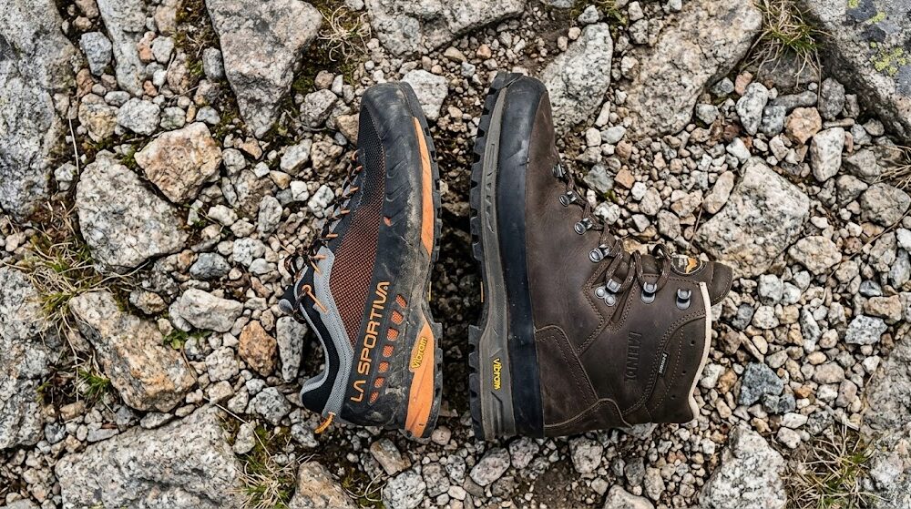 Po prawej klasyczny, wysoki, skórzany traper trekkingowy, po lewej niski but.