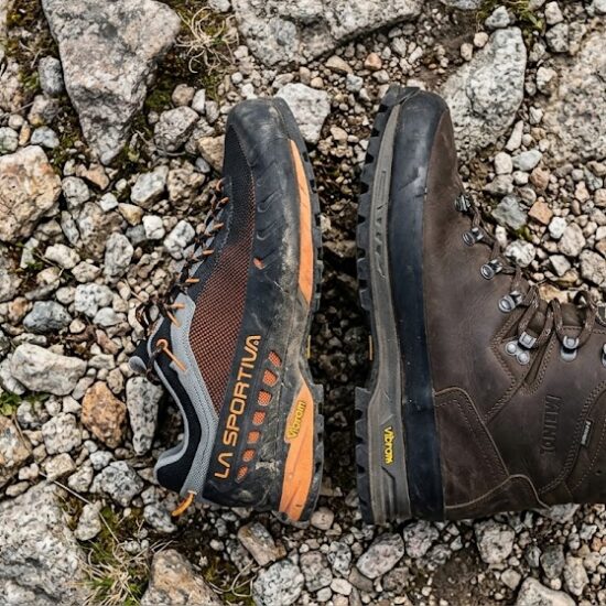 Po prawej klasyczny, wysoki, skórzany traper trekkingowy, po lewej niski but.