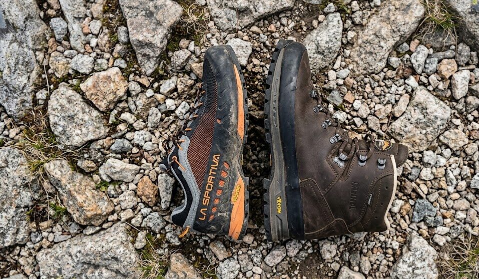 Po prawej klasyczny, wysoki, skórzany traper trekkingowy, po lewej niski but.
